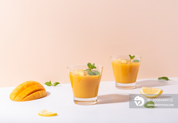 Fresh mango smoothie and ripe mango slice on color background. summer drink.