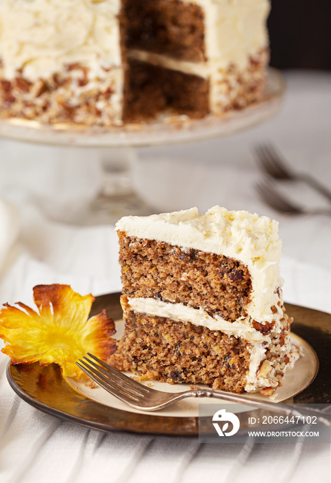 Slice of Hummingbird cake with cream cheese frosting with a pineapple flower