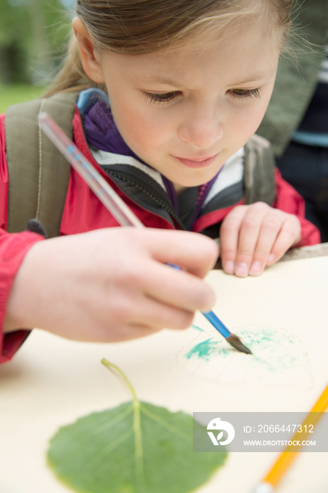 elementary students painting leaf drawing outdoors