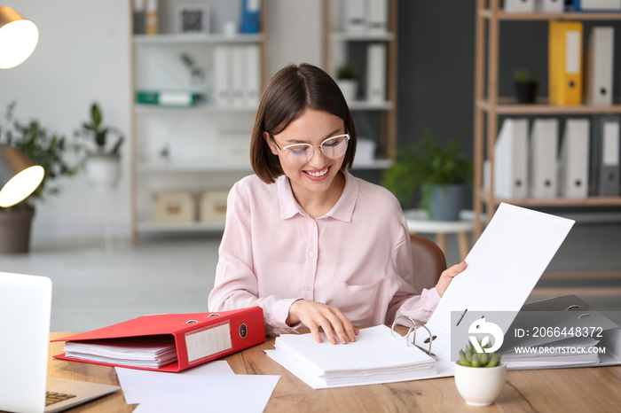 Young woman working with documents in office