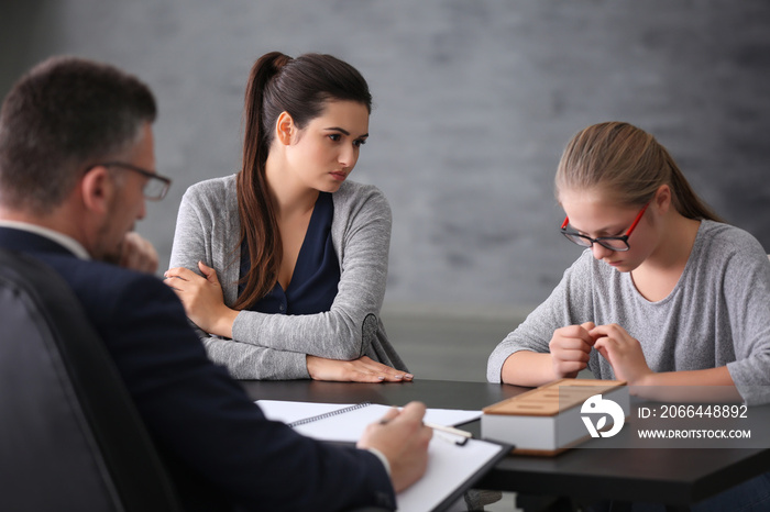 Young woman with daughter during teacher-parent meeting at school