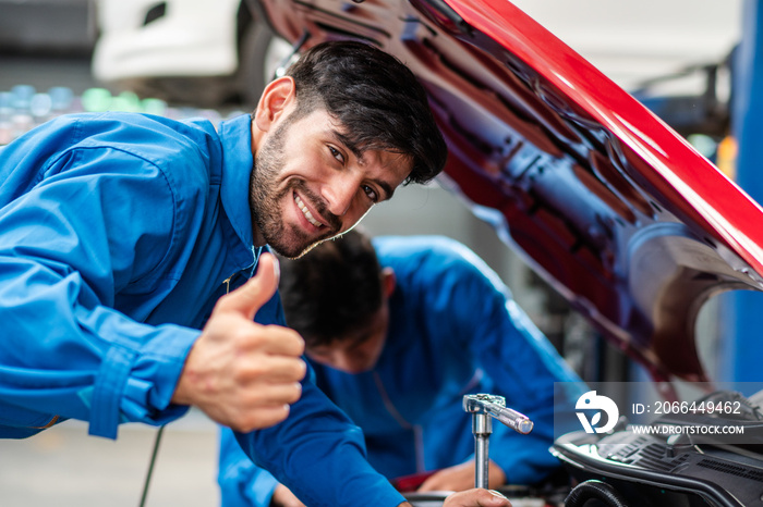 Happy smile Caucasian male mechanic showing thumbs up while checking car damage, diagnostic and repa