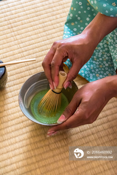 非洲裔美国女性客人用手在茶碗里搅拌抹茶