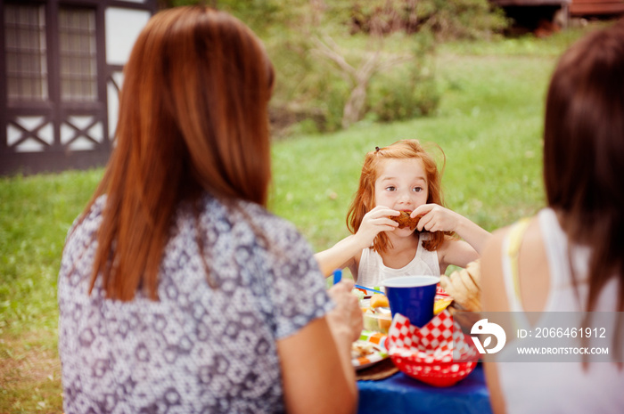 Mother and daughter eating in garden