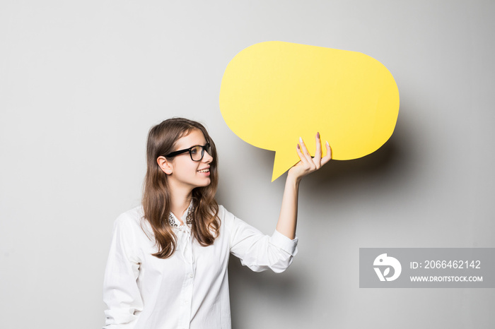 Business woman holding a speech bubble isolated on gray background.