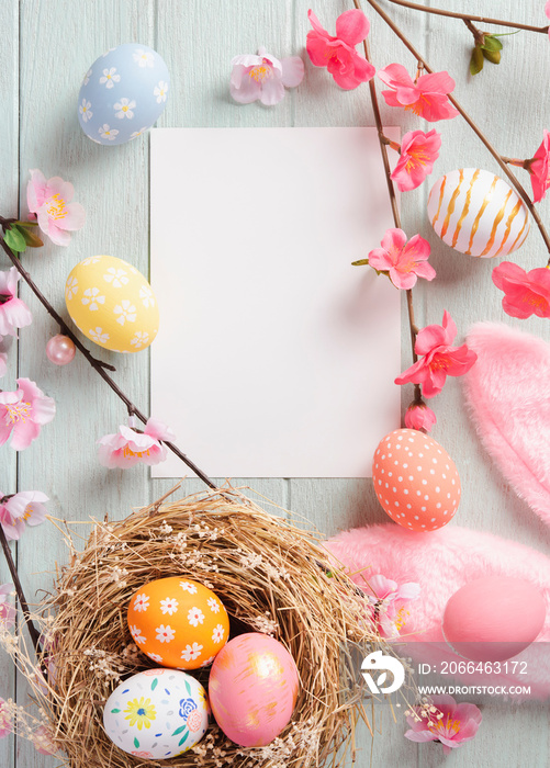 Happy easter, mockup paper card and easter painted eggs in nest on wooden table. Top view with copy 