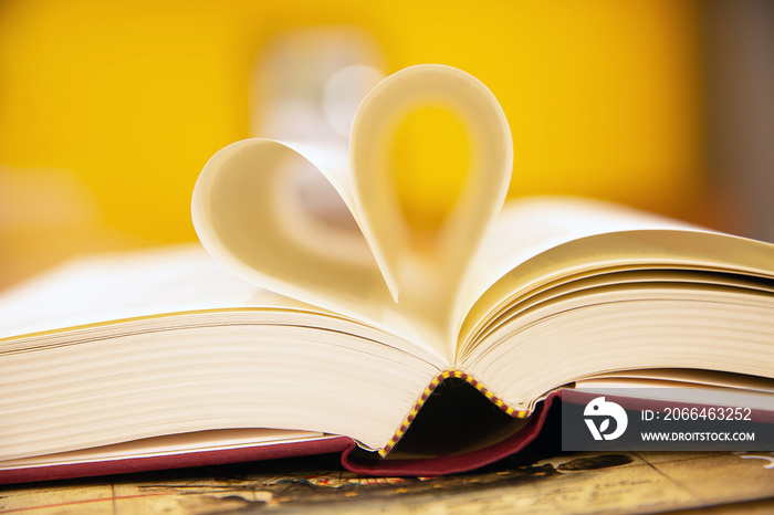 在图书馆房间的桌子上特写一本心形的书——生活方式的概念——喜欢阅读。