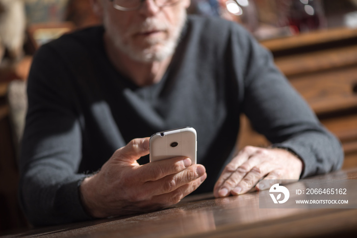 Senior man using his phone, hard light effect