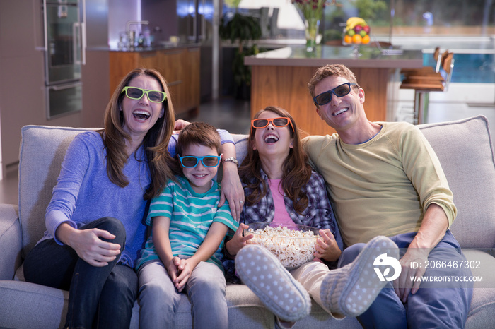 Happy family in 3D glasses watching movie on sofa
