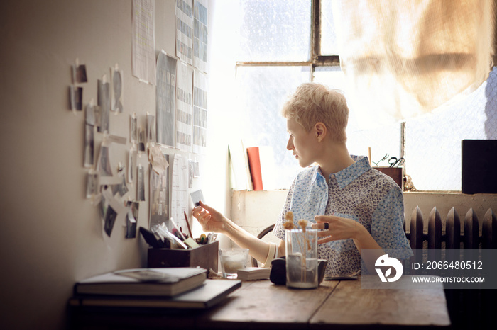 Young woman hanging pictures on wall