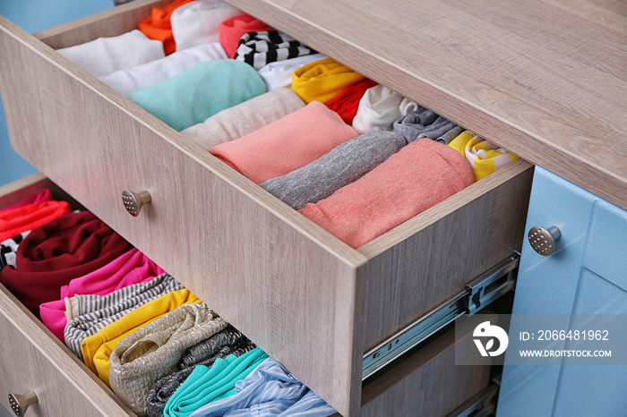 Neatly folded clothes in chest of drawers