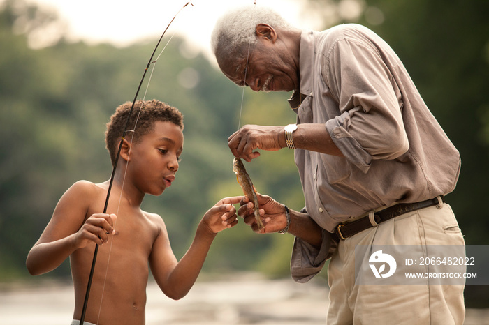 Boy and grandfather looking at fish