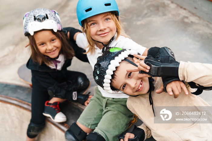 Happy cheerful kids with skateboards at the ramp