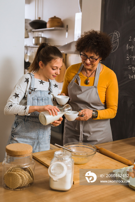 grandmother with her granddaughter baking in kitchen