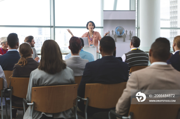 Female speaker with laptop speaks in a business seminar