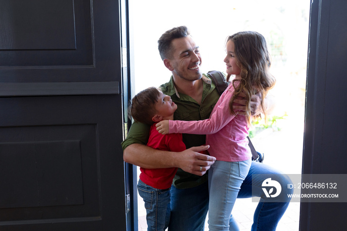 Happy caucasian siblings welcoming father returning home after work