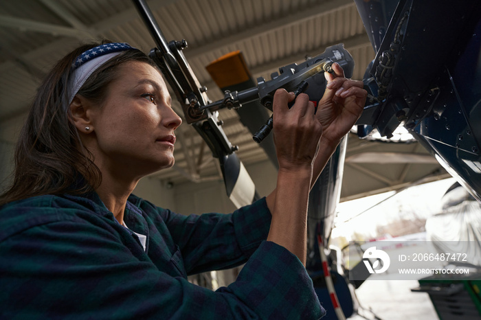 在航空车库工作的Brunette高加索女性空气框架机械师