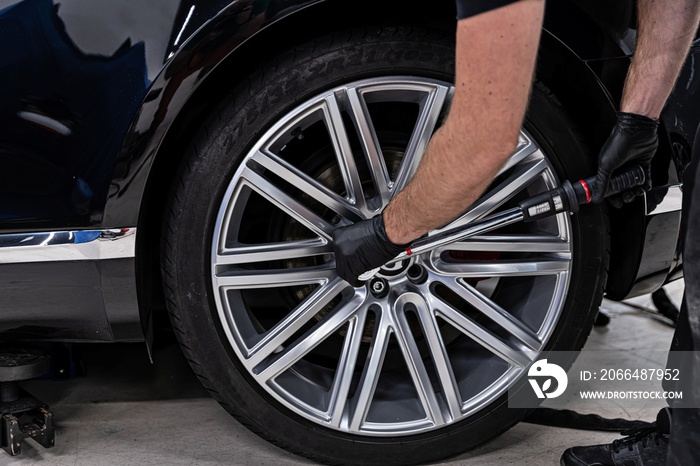 Car mechanic changing car wheel and tire