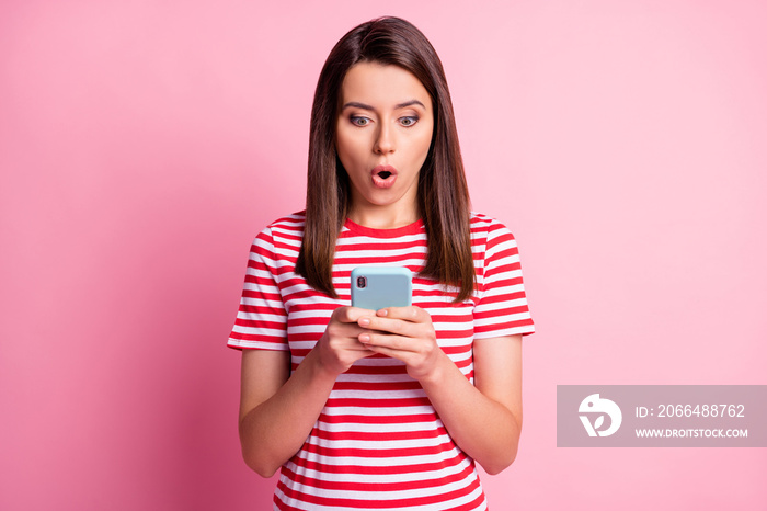 Portrait of impressed young woman staring telephone open mouth wear read white t-shirt isolated over