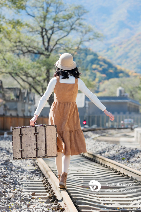 青年女人在铁轨上行走