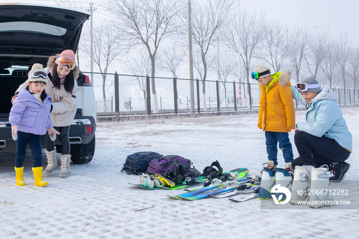 停车场内清点滑雪装备的一家四口