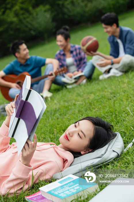 大学生在草地上享受课余时间