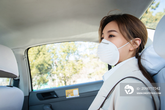 年轻女人戴口罩乘坐汽车