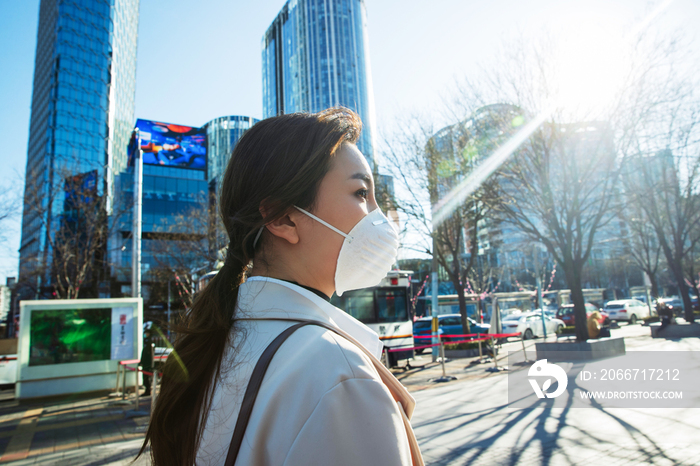 青年女人戴口罩在户外行走