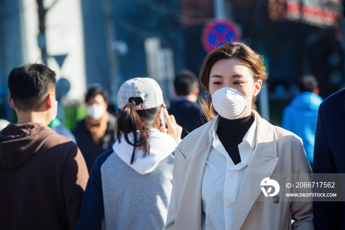 青年女人戴口罩在户外行走