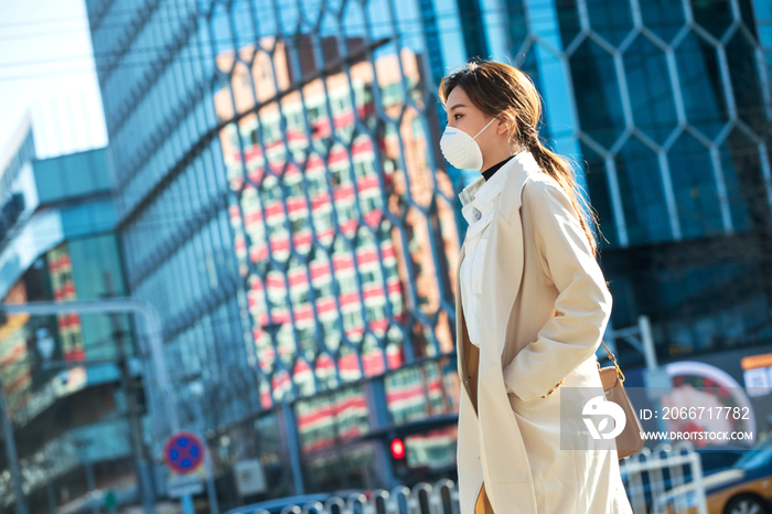 青年女人戴口罩在户外行走