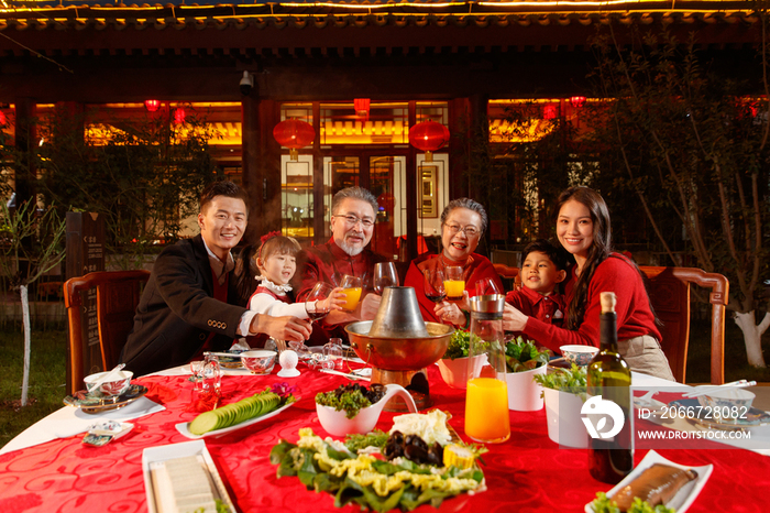 东方家庭在中式庭院内干杯庆祝新年