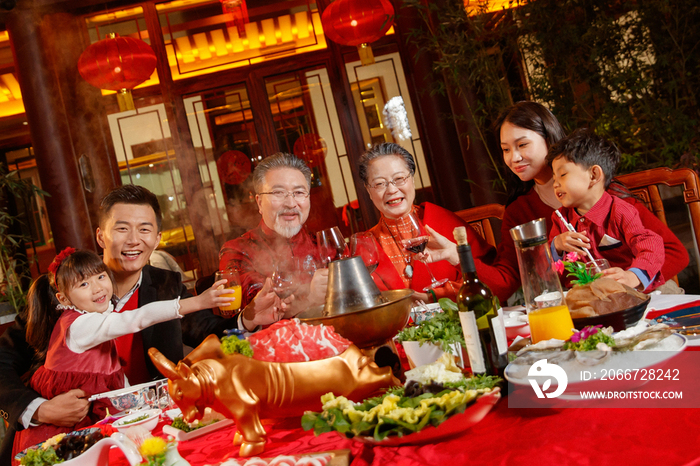 东方家庭在中式庭院内干杯庆祝新年