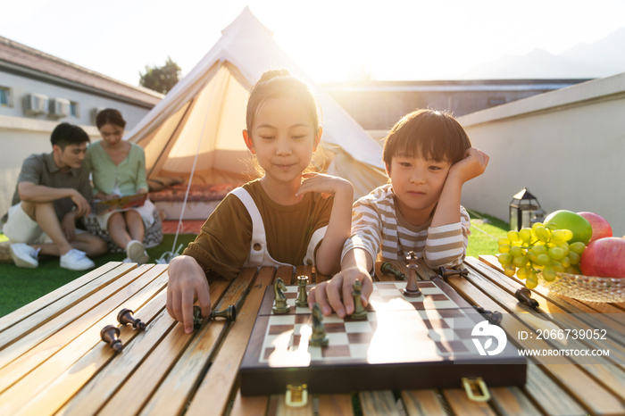 在户外露营的快乐儿童下国际象棋