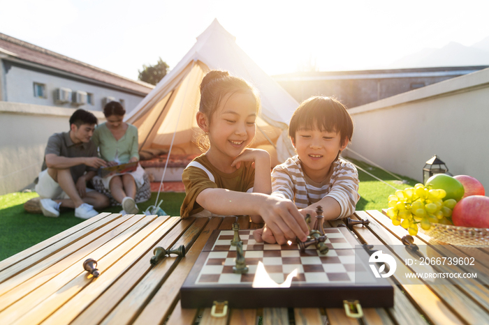 在户外露营的快乐儿童下国际象棋