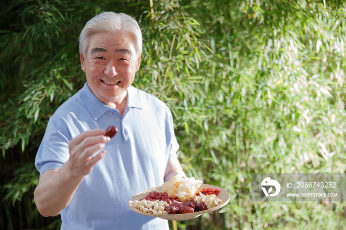 一个老年男人拿着干果