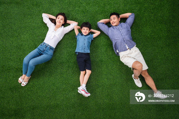 幸福的一家三口躺在草地上