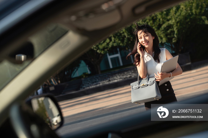 打电话的青年女人走向汽车