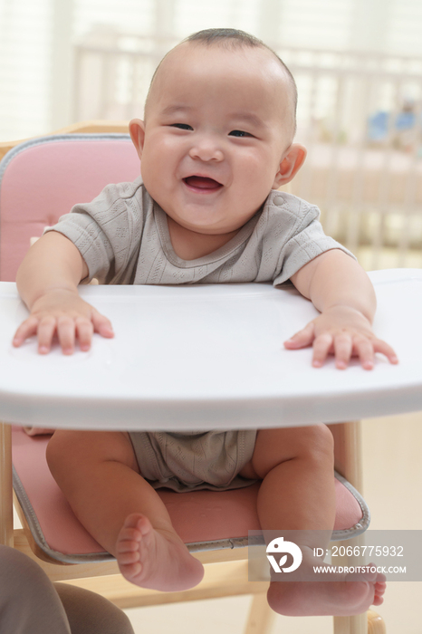 可爱的宝宝坐在宝宝椅上