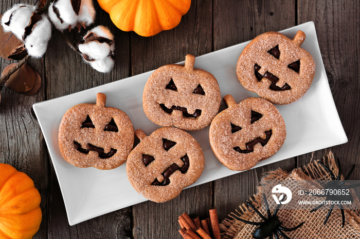 Plate of Halloween Jack o Lantern cookies. Chocolate and pumpkin spice. Above view with decor on a d