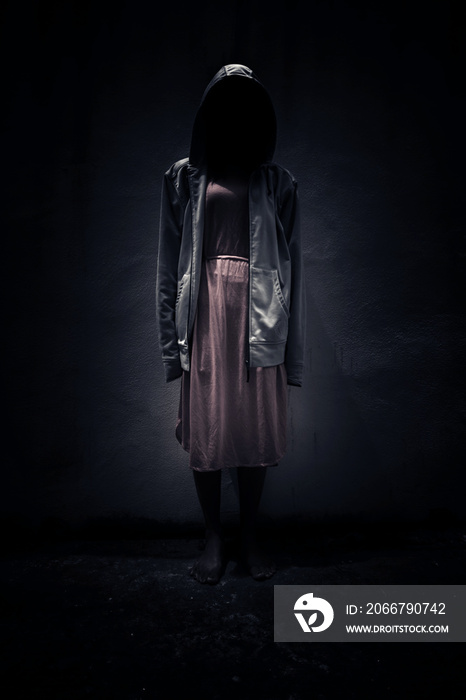 Woman wearing hoodie hiding in the dark,Scary background for book cover