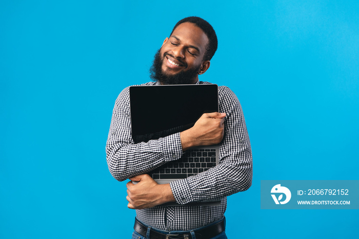 Smiling african american guy holding personal computer