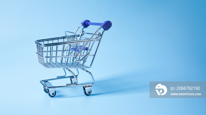 Empty shopping basket or grocery cart on blue with shadow.