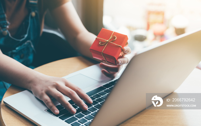 Woman hand holding red gift box about shopping online concept.