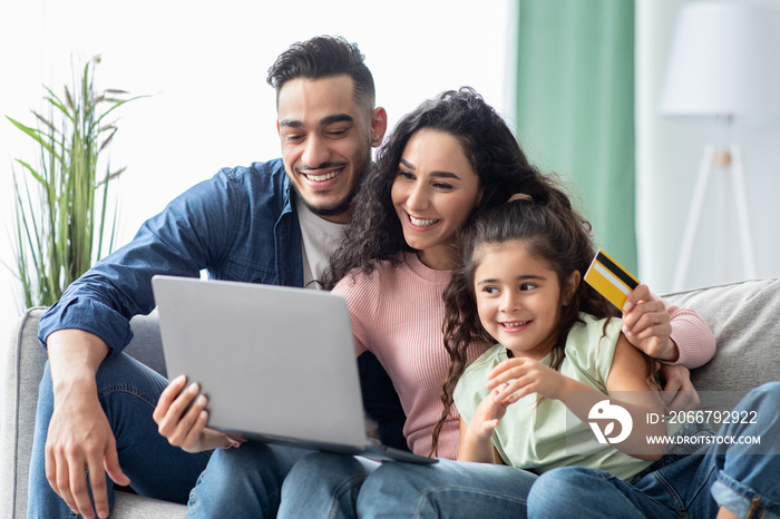 Middle Eastern Family Of Three With Laptop And Credit Card At Home