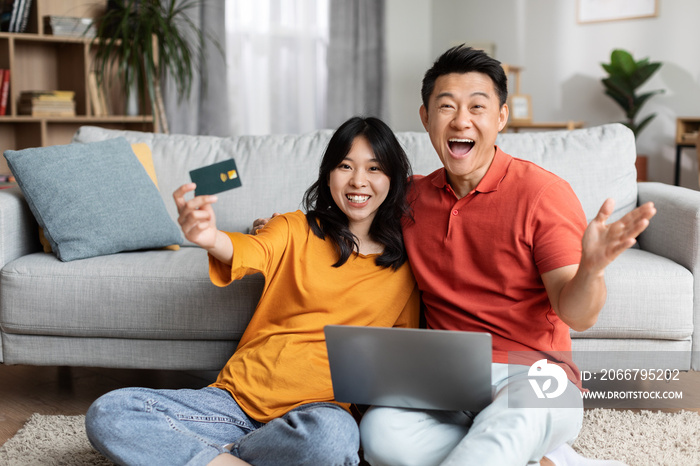 Excited asian family shopping online at home, using computer