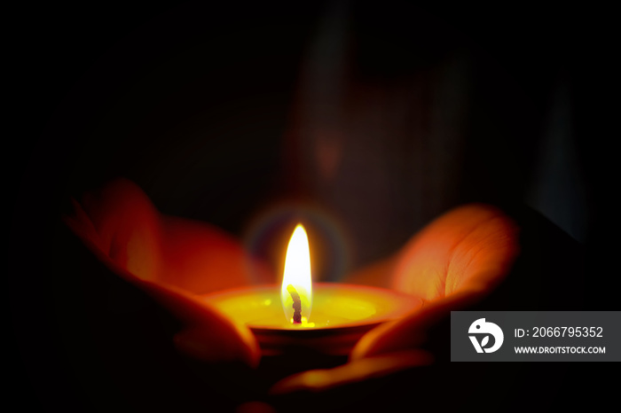 Prayer and hope concept of candle light in hands