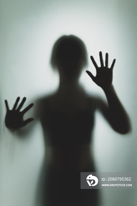 Ghost concept shadow of a woman behind the matte glass blurry hand and body soft focus