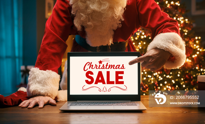 Santa Claus showing Christmas advertisements on the laptop