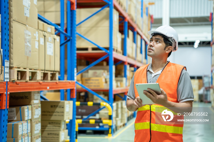 asian man business owner using checklist recheck amount of stock product inventory on shelf at distr