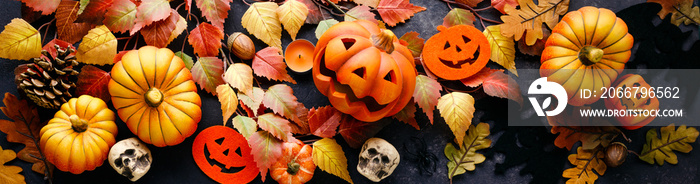 Pumpkins with Halloween decorations on dark background